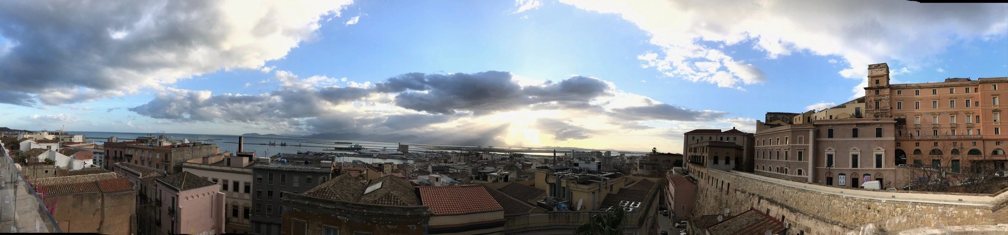 Vaccine in a bottle banner image -Panoramic photo of the coastal town of Cagliari